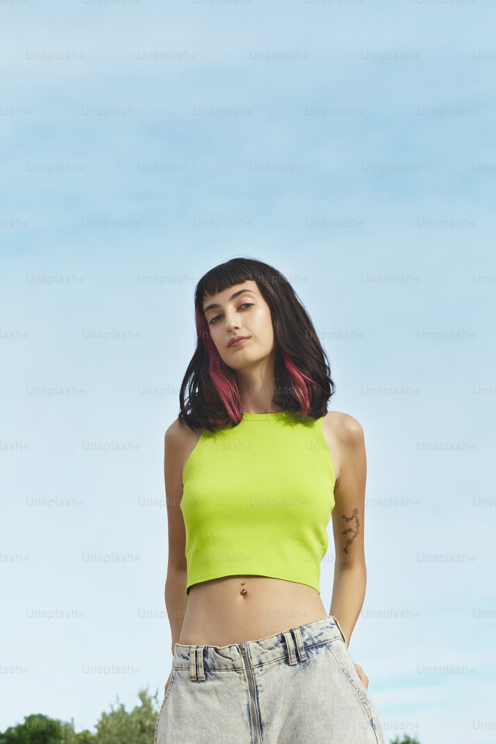 a woman in a yellow crop top posing for a picture