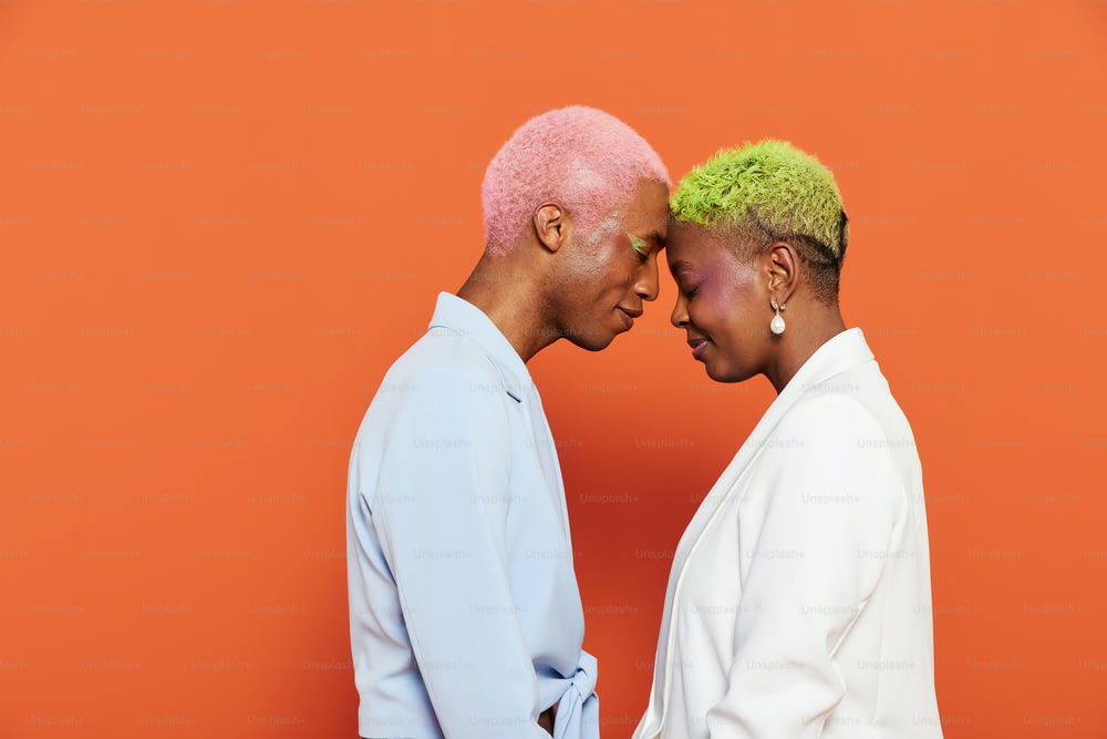a man and a woman with pink and green hair
