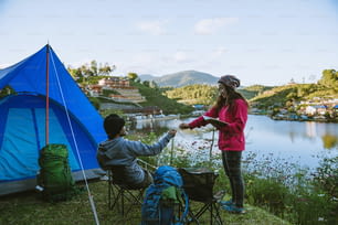 Couple Enjoying Camping Holiday In Countryside.Camp in the mountains near of the lake.