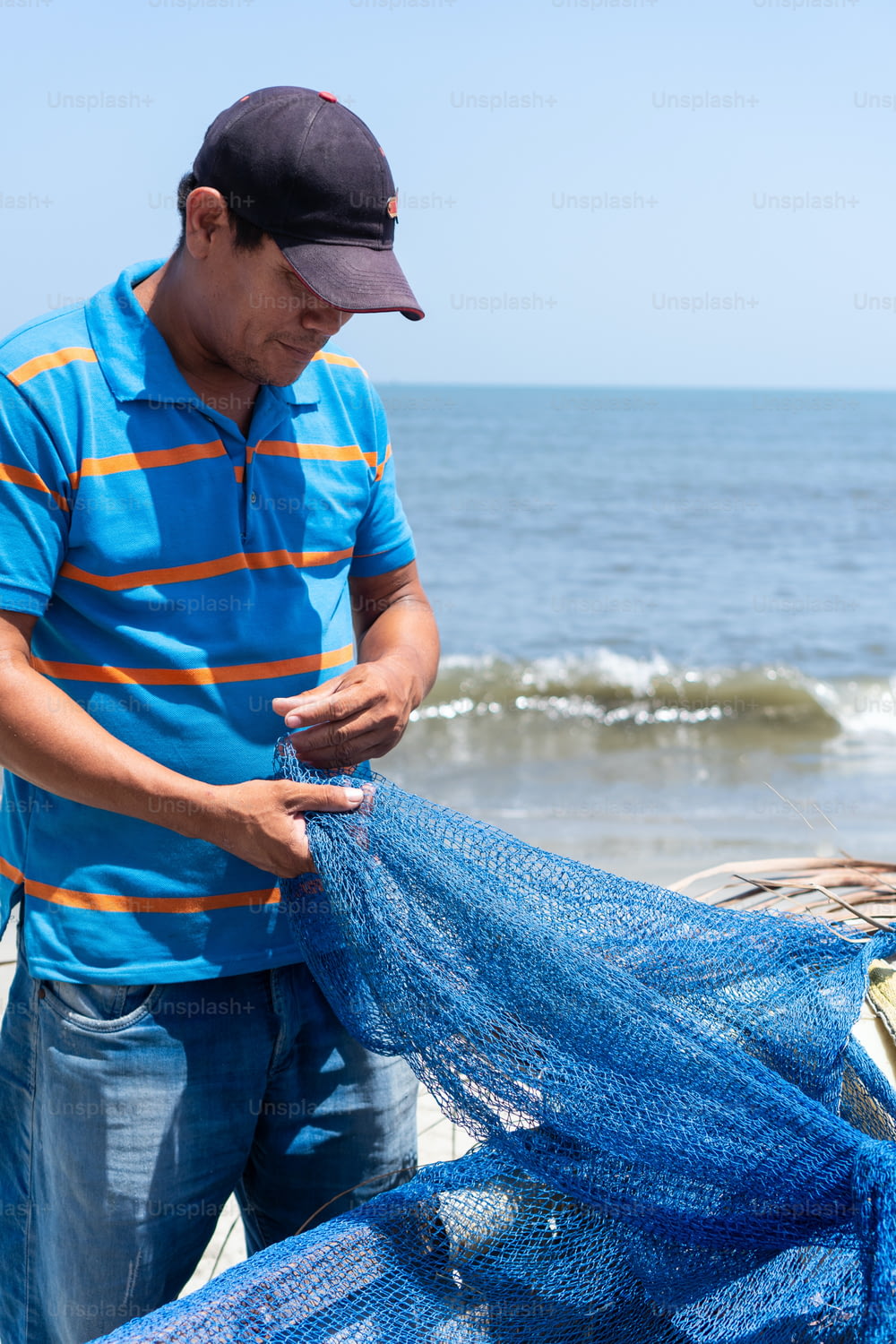 Latin fisherman checking a fishing net on a fishing boat