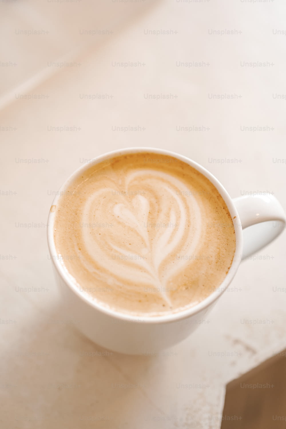 un cappuccino avec un motif de feuille dans une tasse blanche