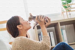 Young Asian woman holding and playing with her cute kitten cat with lovely moment, pet and human concept
