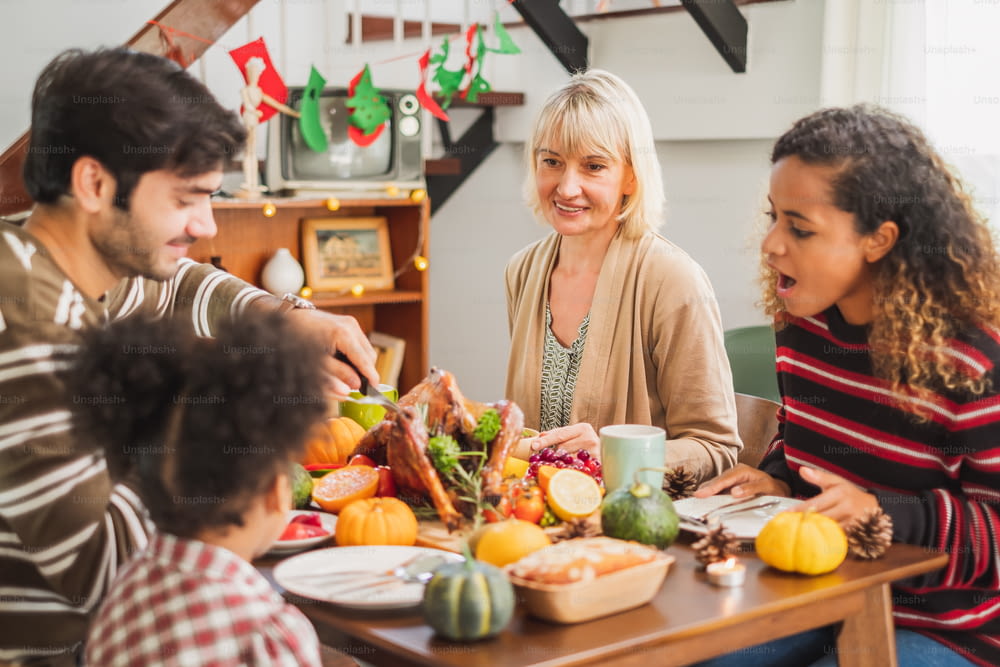 Happy Thanksgiving Dinner Party mit Familie und Essen mit Truthahn auf dem Tisch