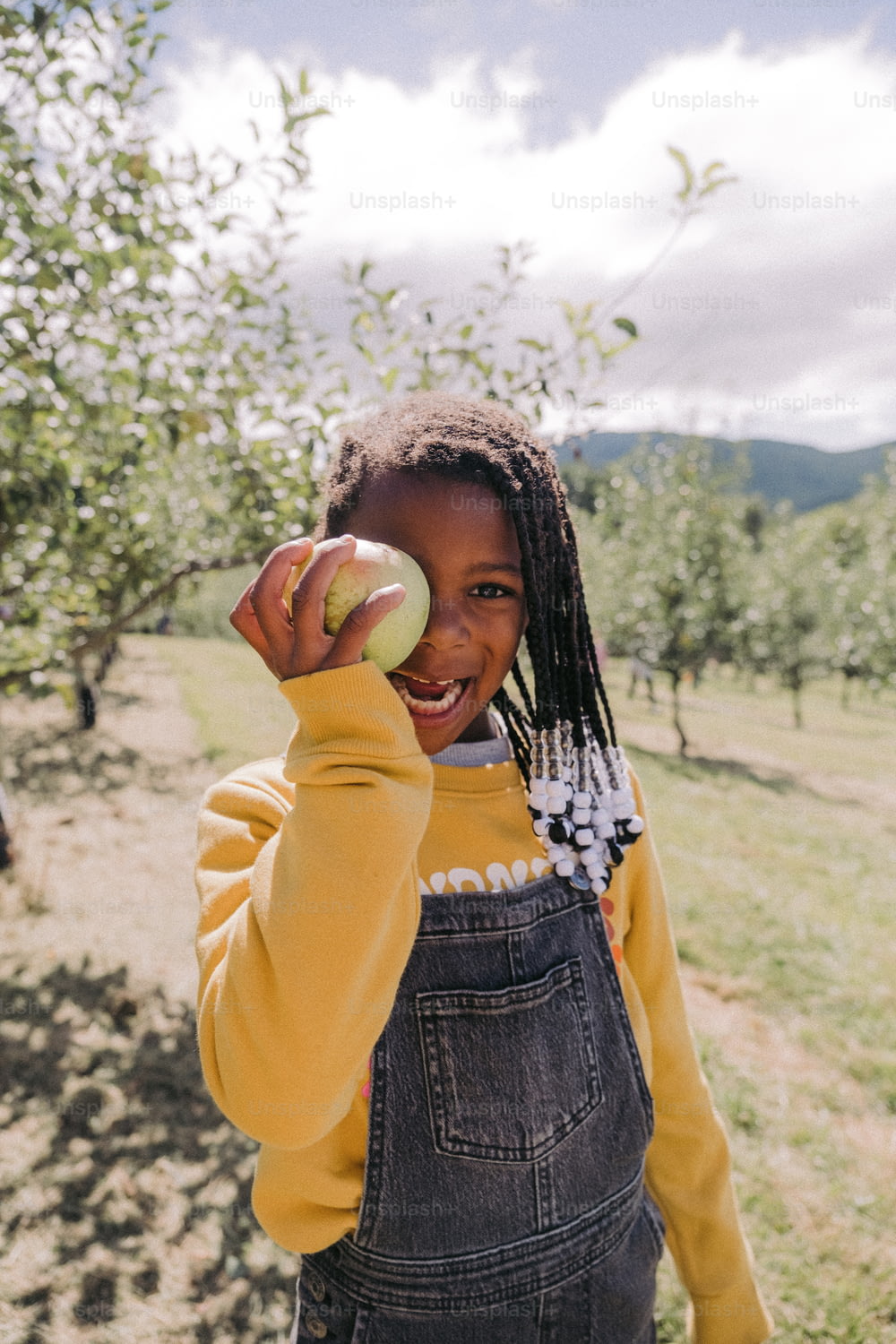 a young girl holding an apple in her hand