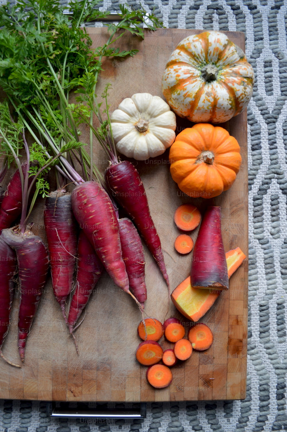 une planche à découper garnie de carottes et d’autres légumes