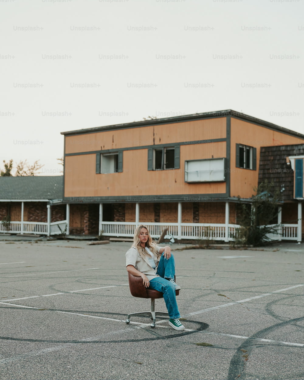 uma mulher sentada em uma cadeira em um estacionamento