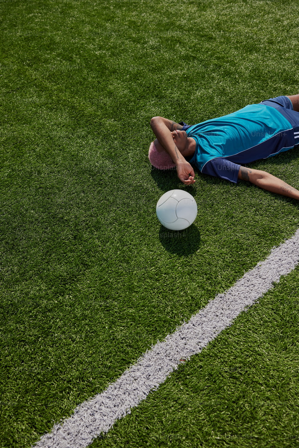 a man laying on the ground next to a white frisbee