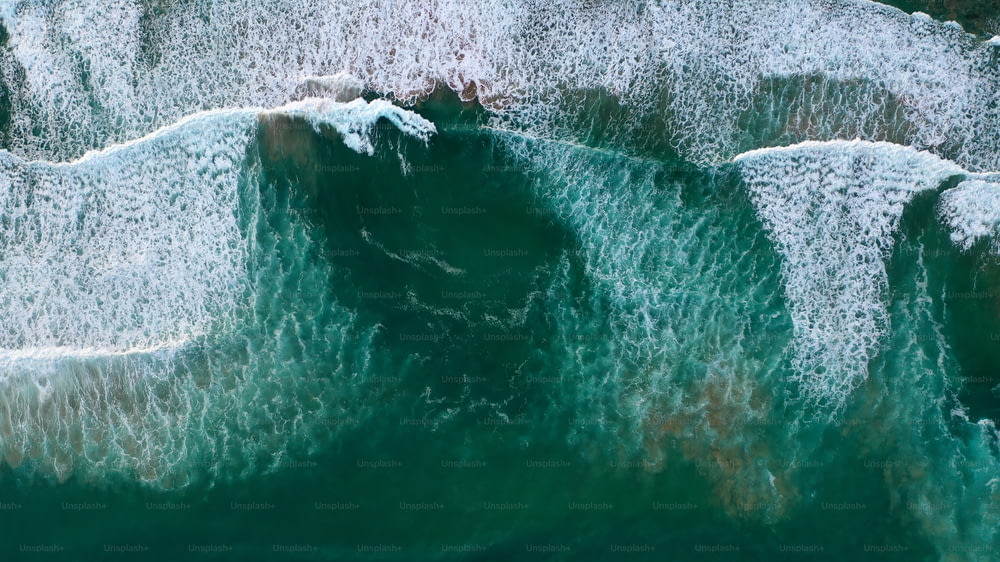 Una vista aérea del océano con olas rompiendo en las rocas