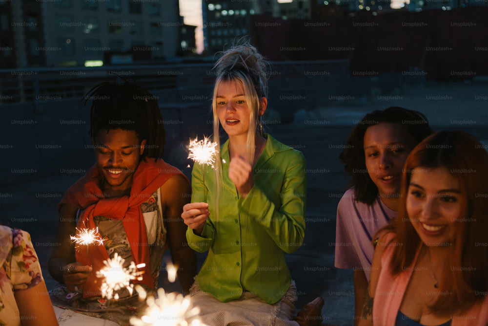 a group of women sitting around a table holding sparklers