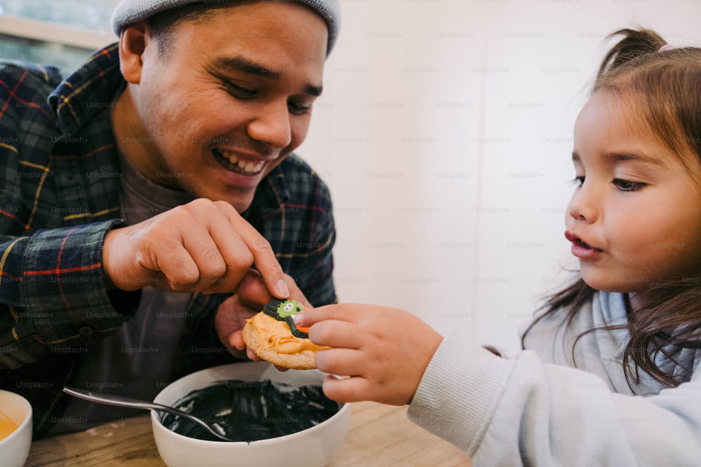 a man feeding a little girl a piece of food