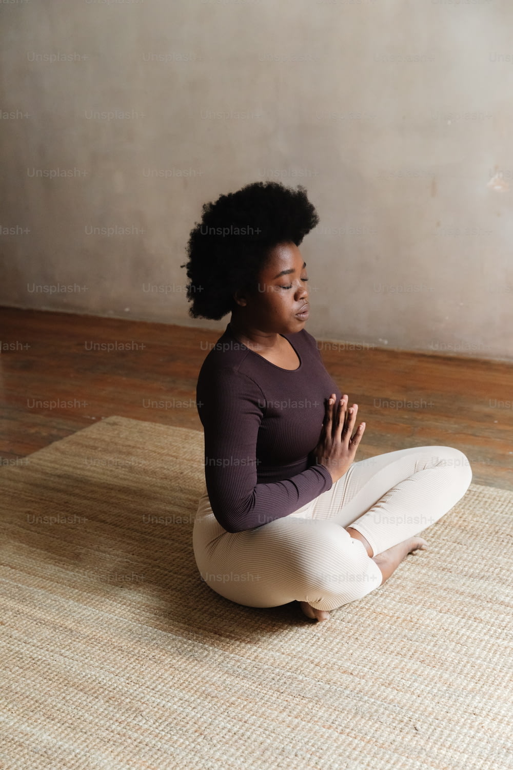 Une femme assise par terre dans une pose de yoga