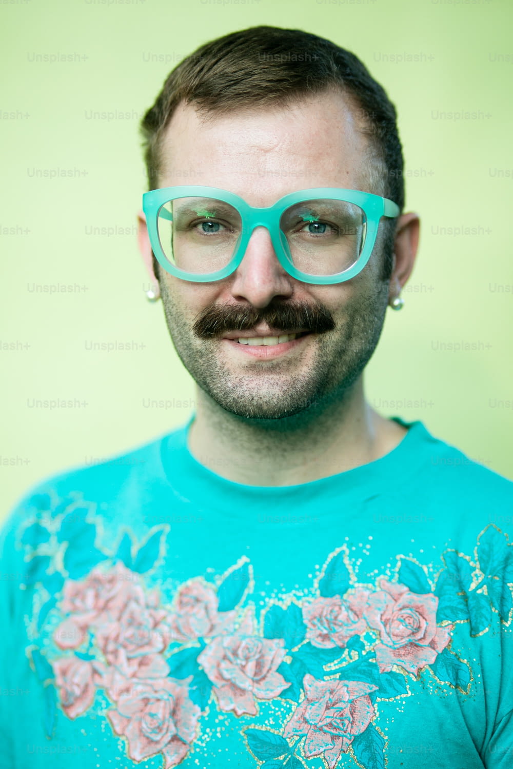 um homem de óculos e bigode vestindo uma camiseta
