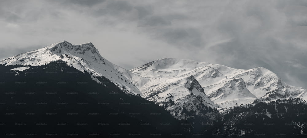 Eine schneebedeckte Bergkette unter einem bewölkten Himmel