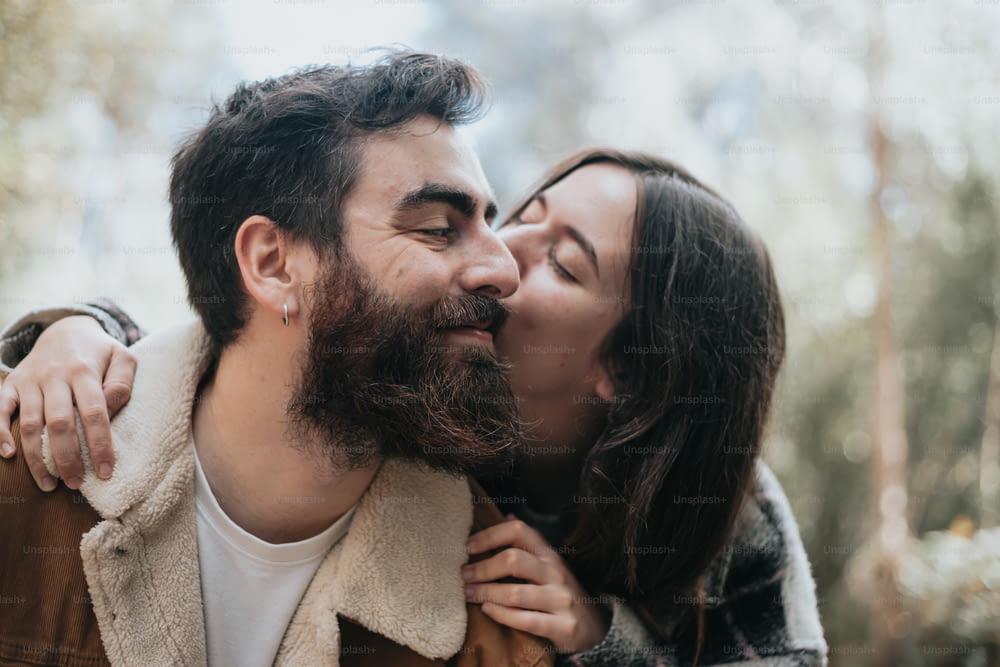 Un hombre y una mujer se besan en el bosque