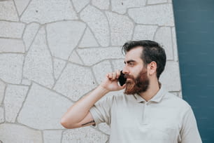 Un homme avec une barbe parlant au téléphone portable