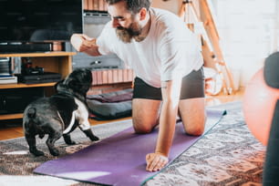 a man is doing yoga with his dog