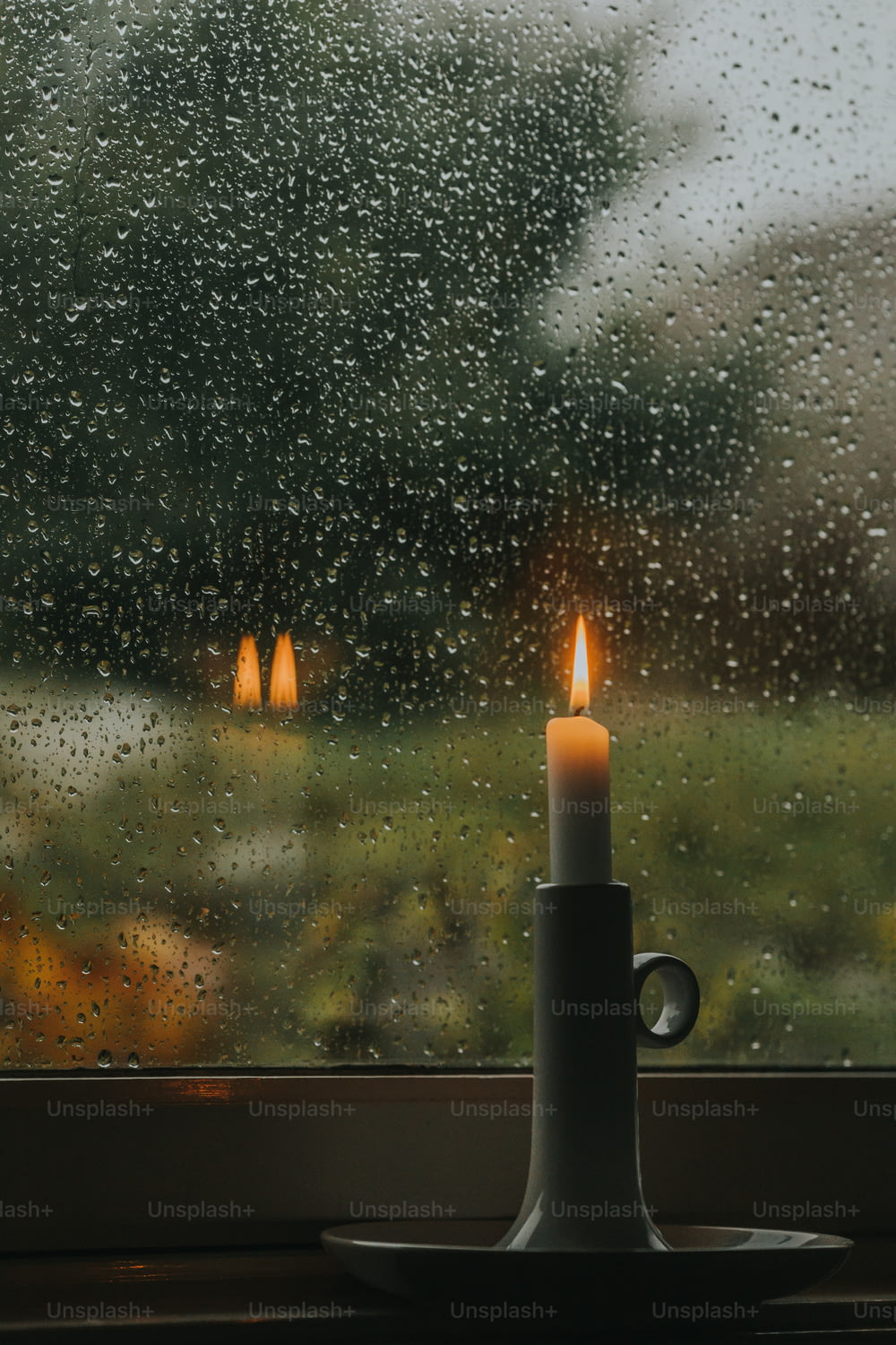 a candle sitting on top of a table next to a window