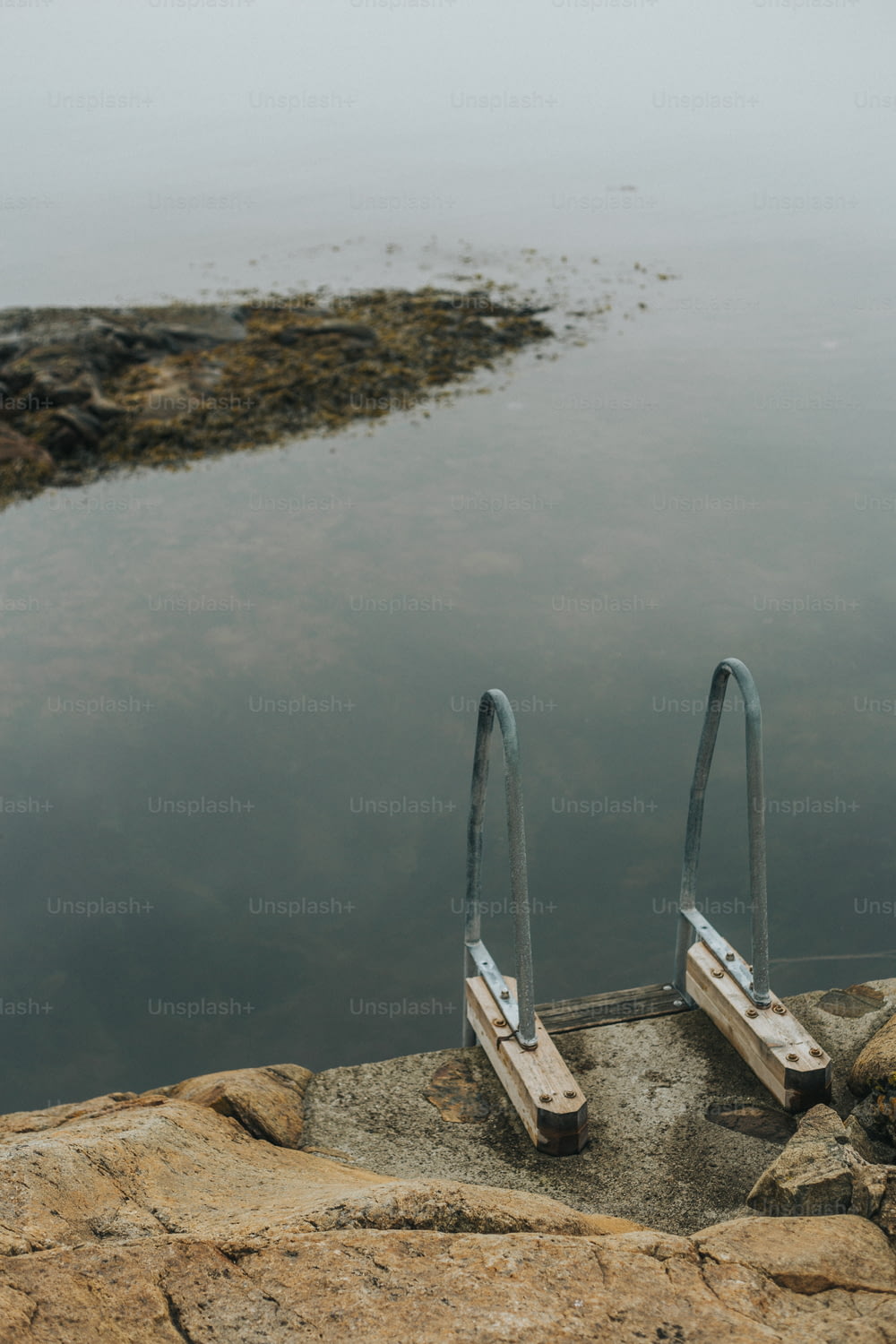 um par de grades de metal sentado ao lado de um corpo de água