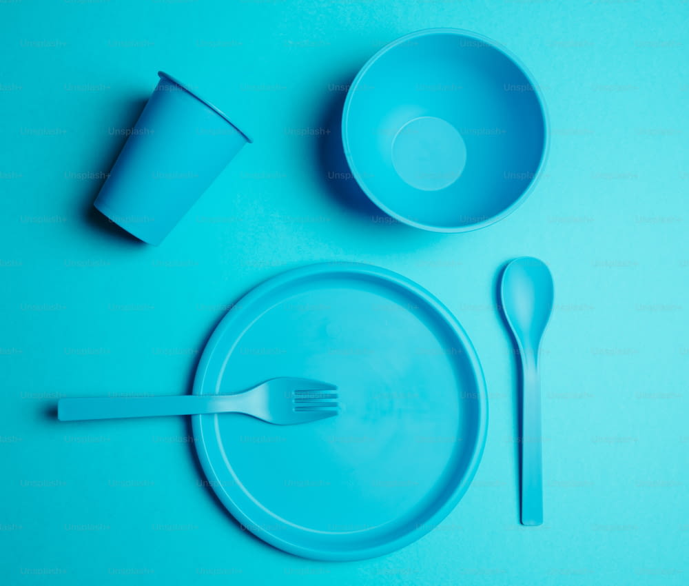 uma mesa de plástico azul com um garfo e um copo