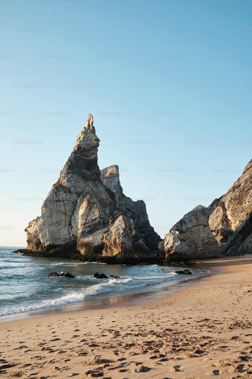 um afloramento rochoso em uma praia ao lado do oceano