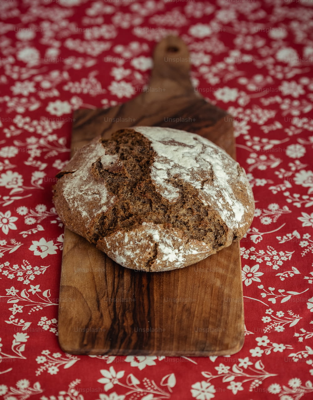 ein Stück Brot, das auf einem hölzernen Schneidebrett sitzt
