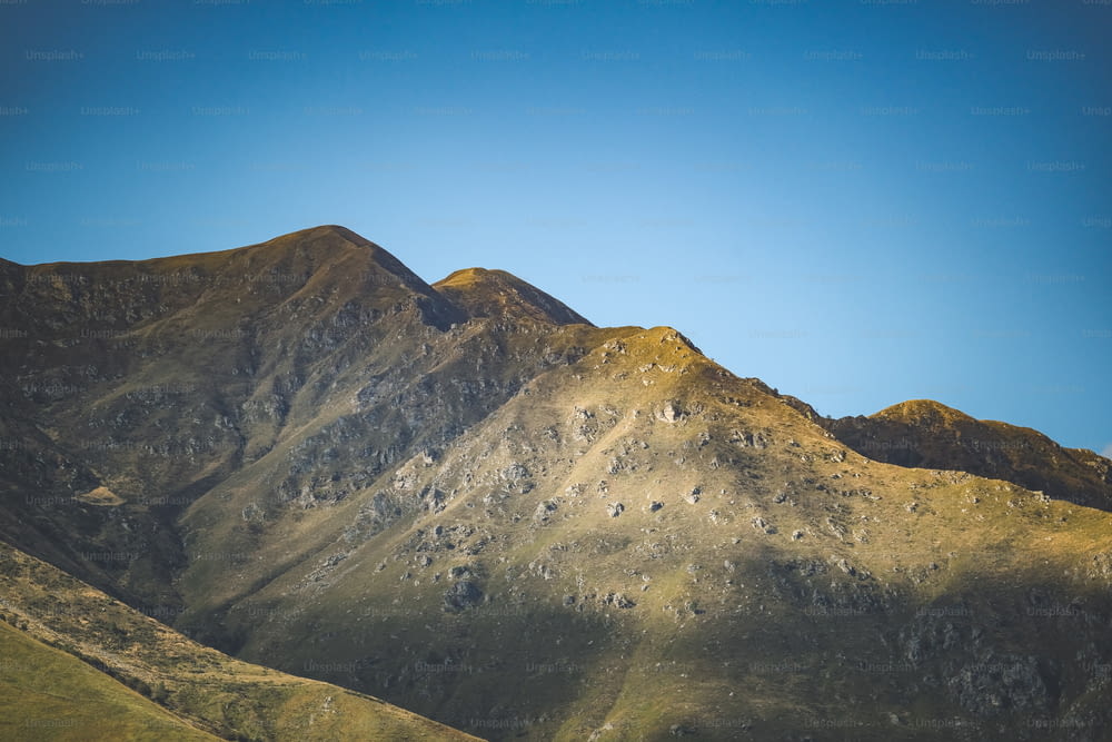 a view of a mountain range with a blue sky in the background