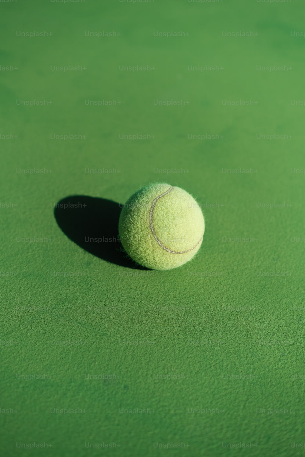 a tennis ball sitting on top of a green court