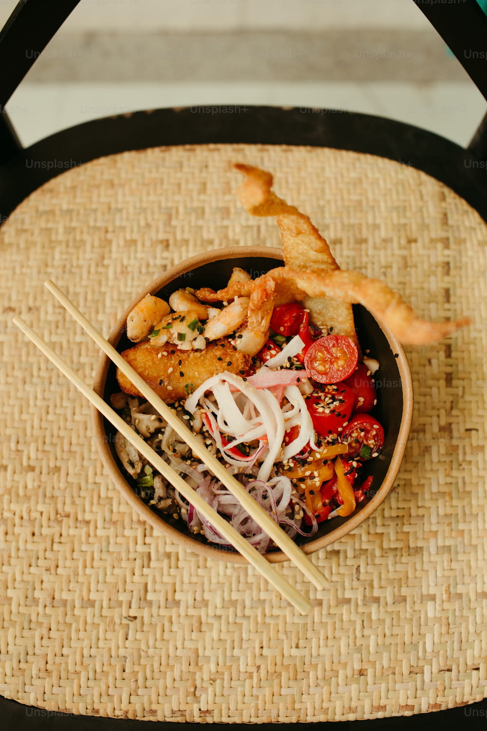 a bowl of food with chopsticks on a chair