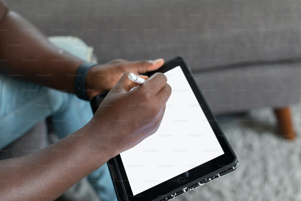 Una donna tiene in mano un tablet con uno schermo bianco