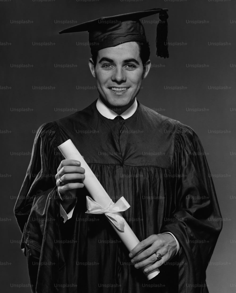 A young man in his graduation gown and mortarboard, holding his diploma, circa 1960. (Photo by George Marks/Retrofile/Getty Images)