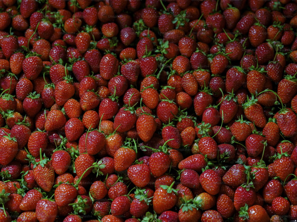 a large pile of strawberries sitting on top of each other