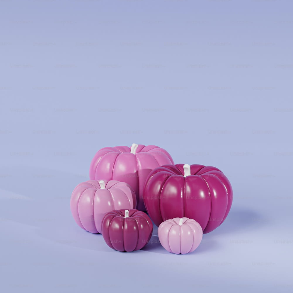 a group of pink pumpkins sitting next to each other