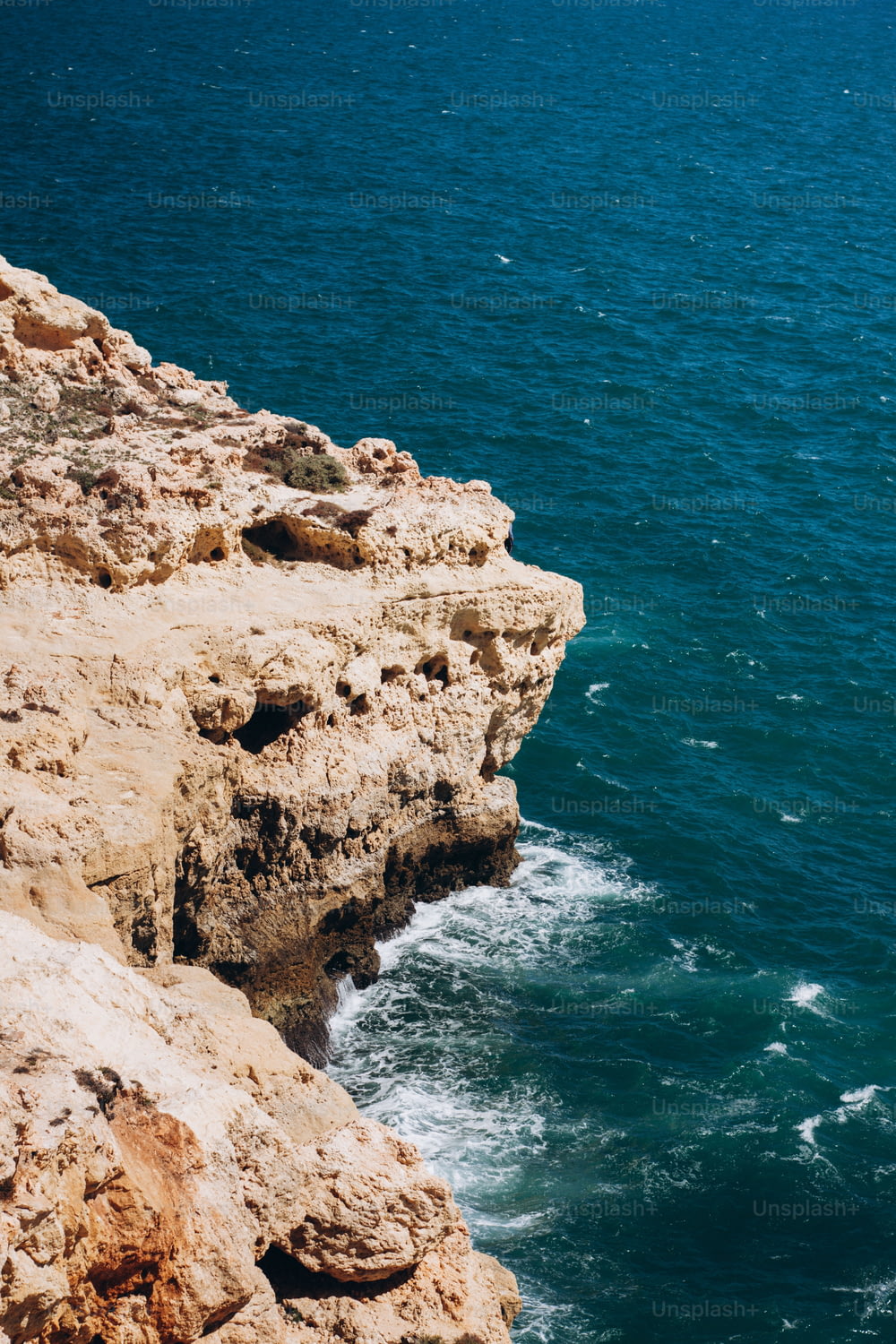 une personne debout sur une falaise surplombant l’océan