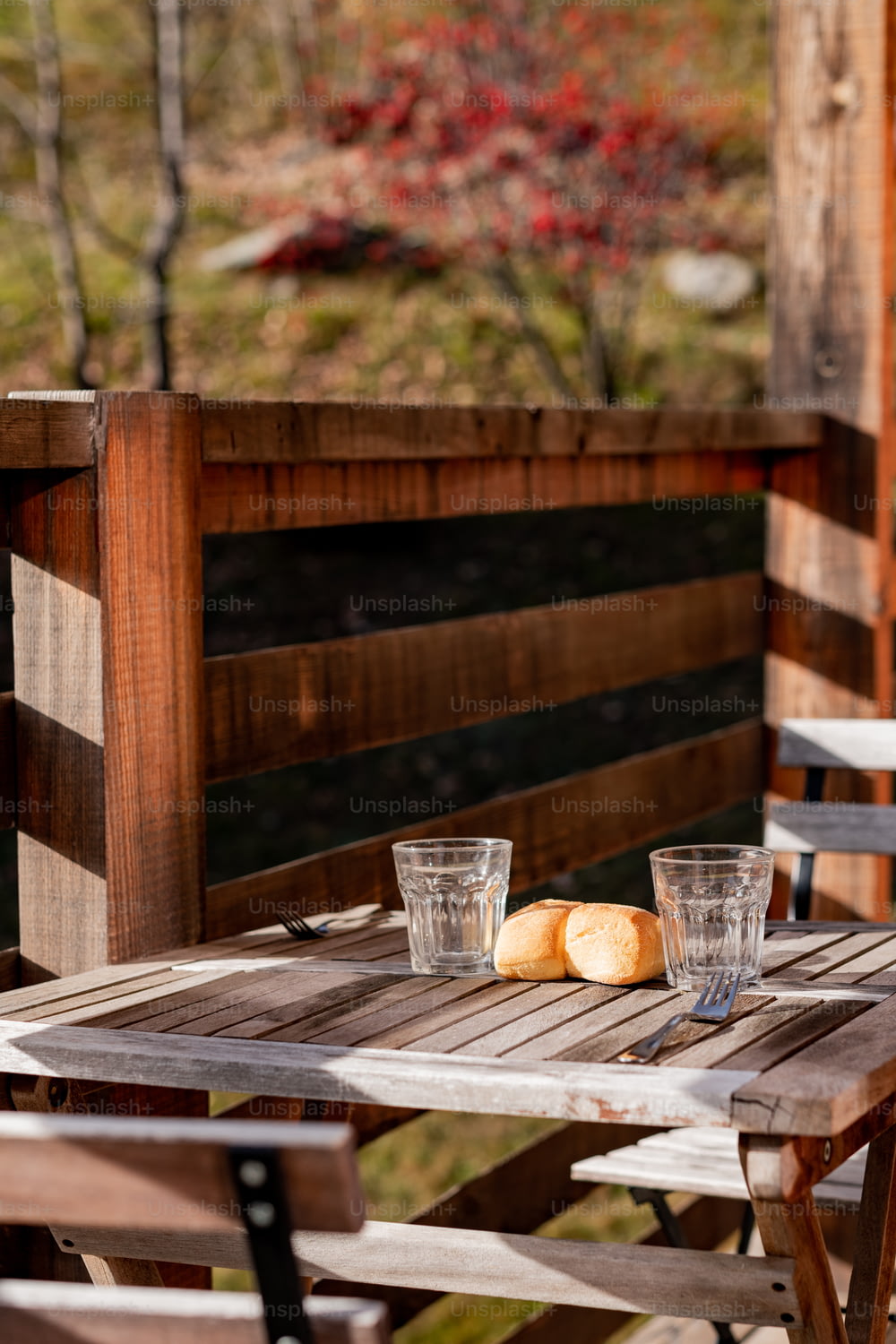 a wooden table with two glasses and bread on it