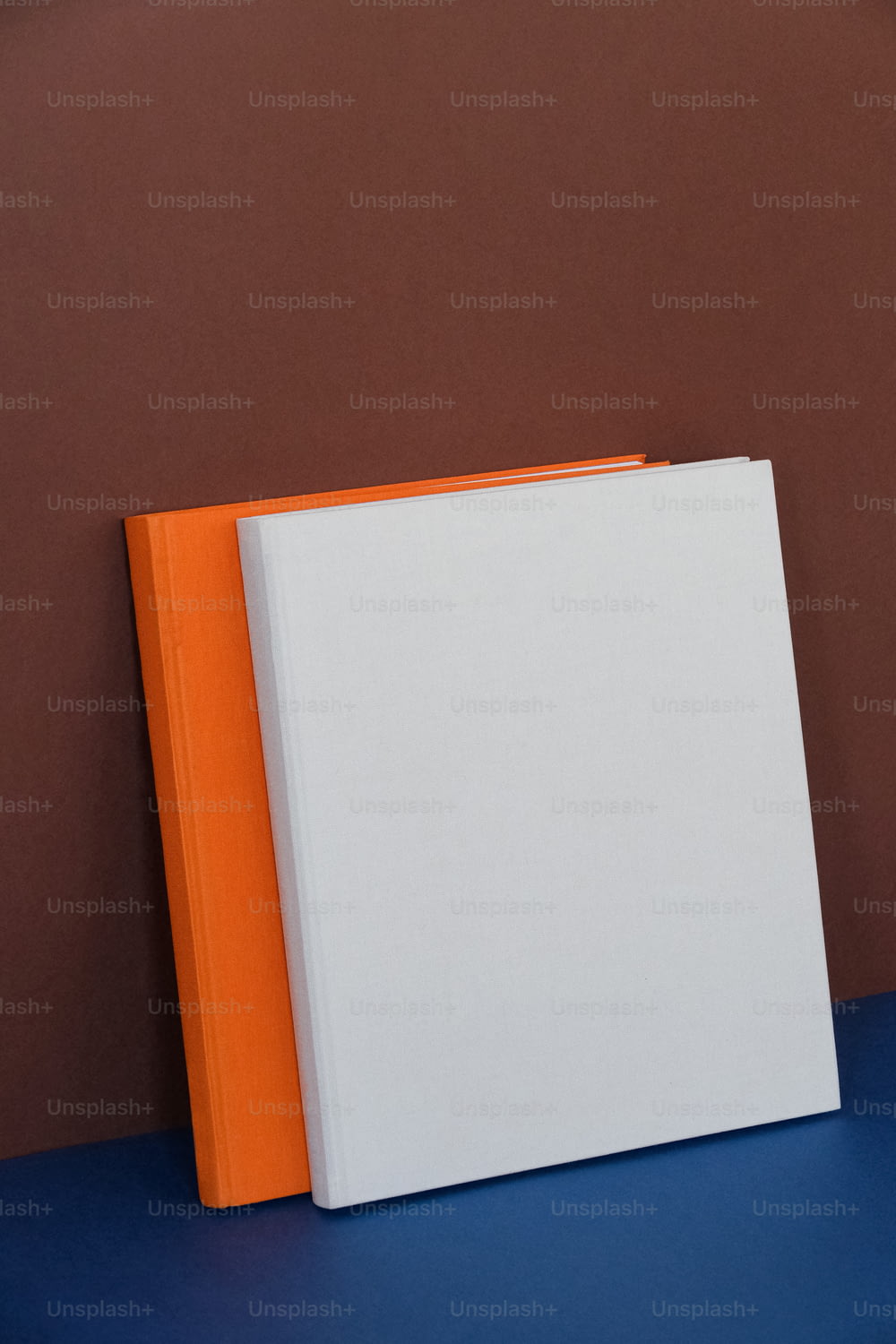 파란색 테이블 위에 놓인 주황색과 흰색의 책