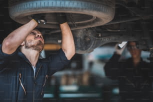 mechanic car service working in garage, workshop to check and maintenance repair automobile, suspension industry technology, vehicle inspection fix man technician work