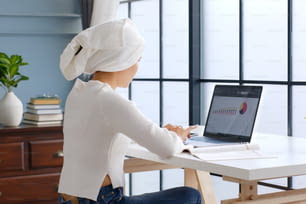 Cabello mojado asiático con turbante mujer de negocios usando computadora portátil trabajo en casa