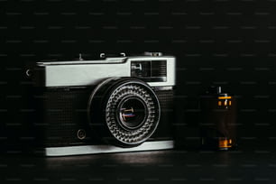 an old fashioned camera next to an empty bottle