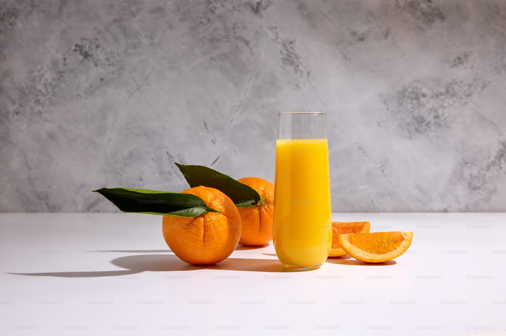 un bicchiere di succo d'arancia accanto ad alcune arance