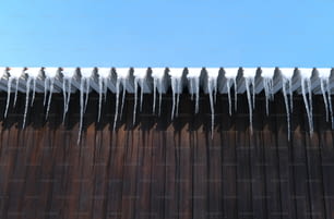 icicles are hanging from the roof of a building