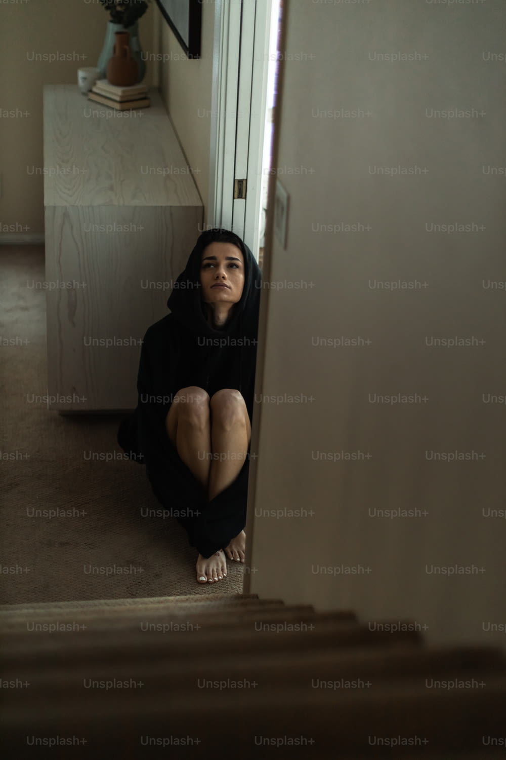 a woman sitting on the floor in front of a door