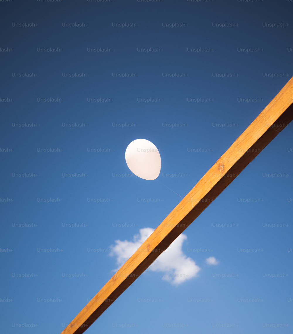 Um frisbee branco está no ar acima de um poste de madeira