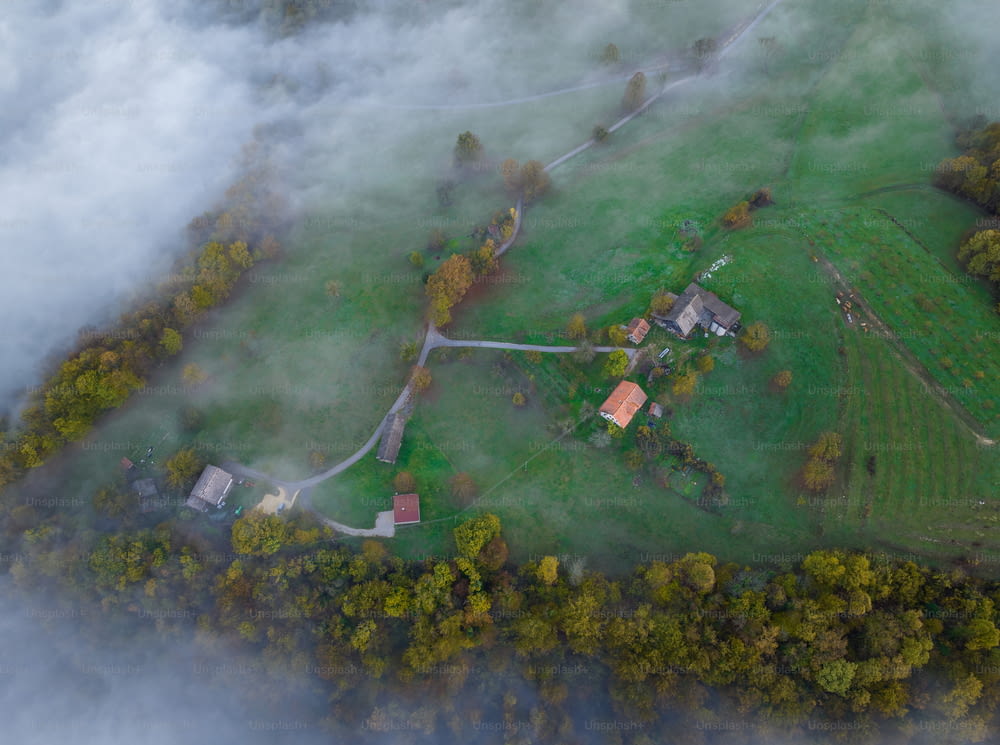 an aerial view of a farm surrounded by clouds