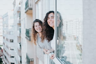 two women are looking out of a window