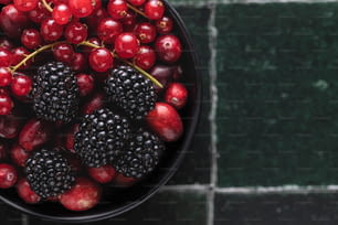 a bowl of berries and blackberries on a table