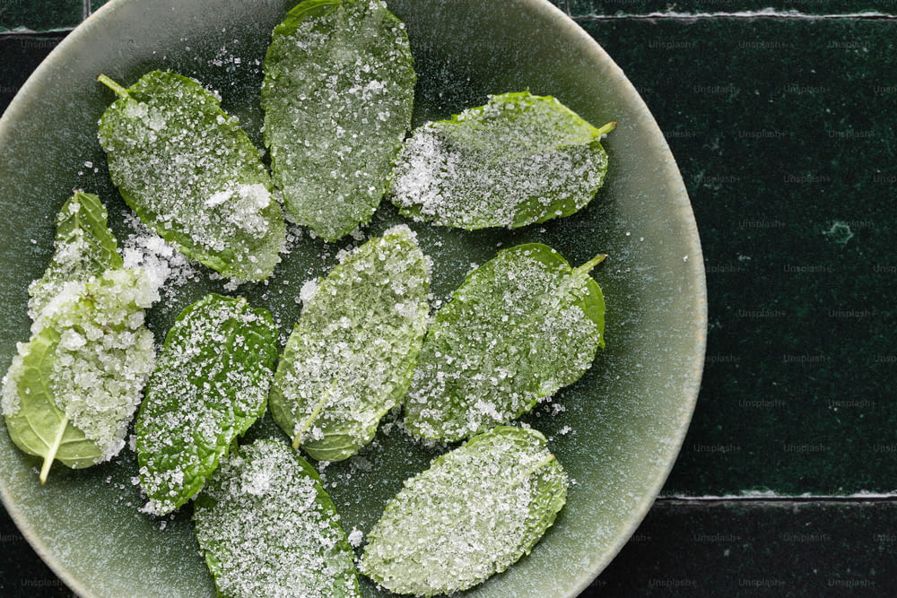 a bowl of green leaves covered in powdered sugar
