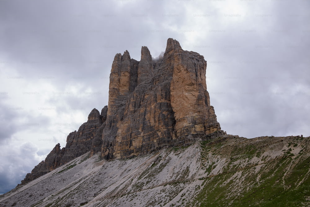 a very tall rock formation on a cloudy day