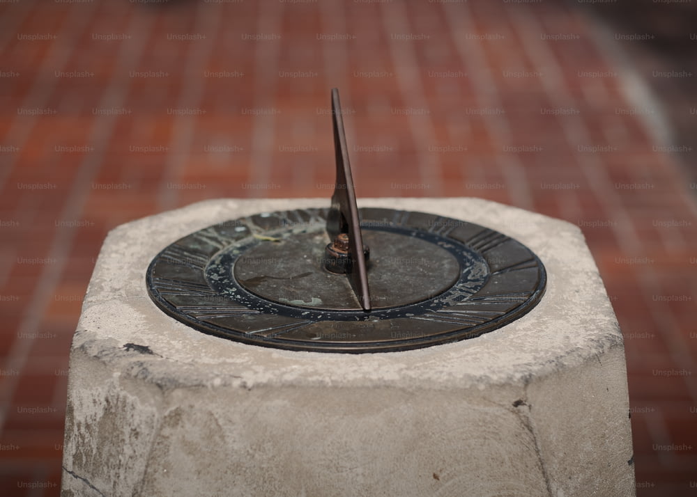 a sundial sitting on top of a cement block