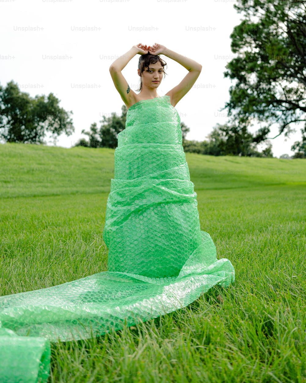 uma mulher em um vestido verde sentado na grama