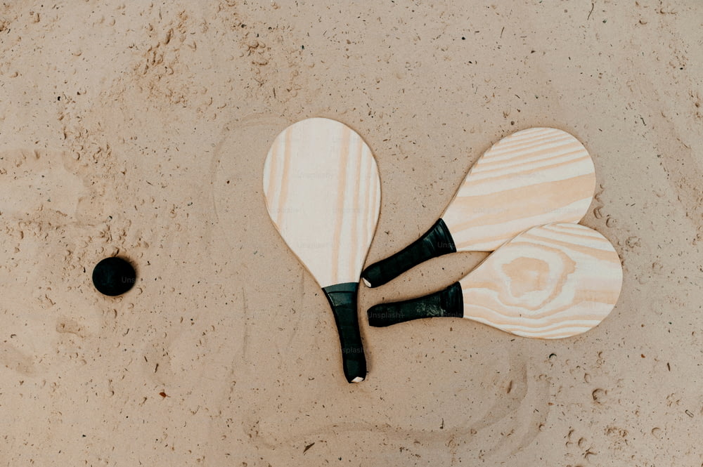a couple of paddles laying on top of a sandy beach